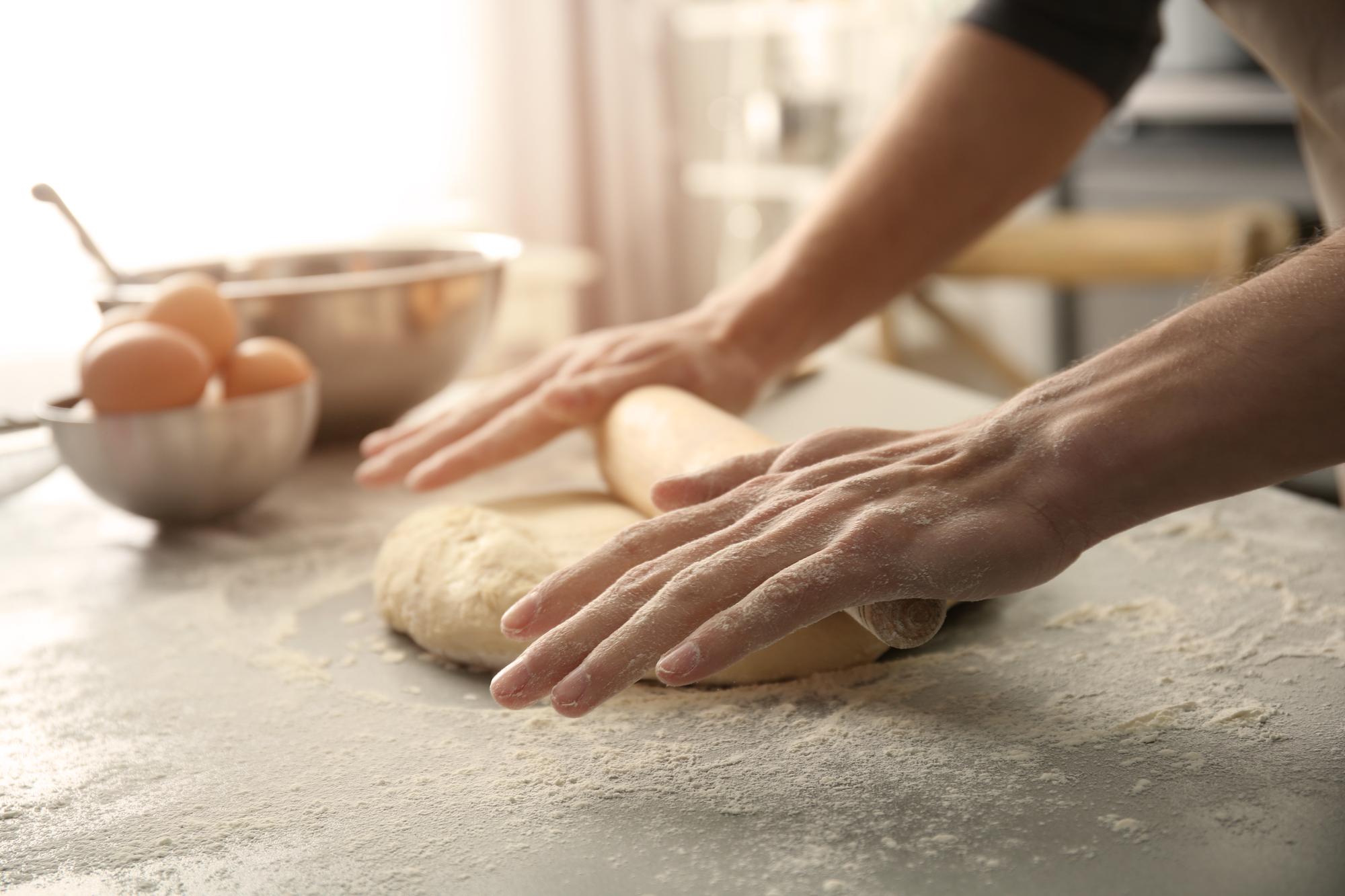 Close-up of hands kneading dough in warm kitchen light