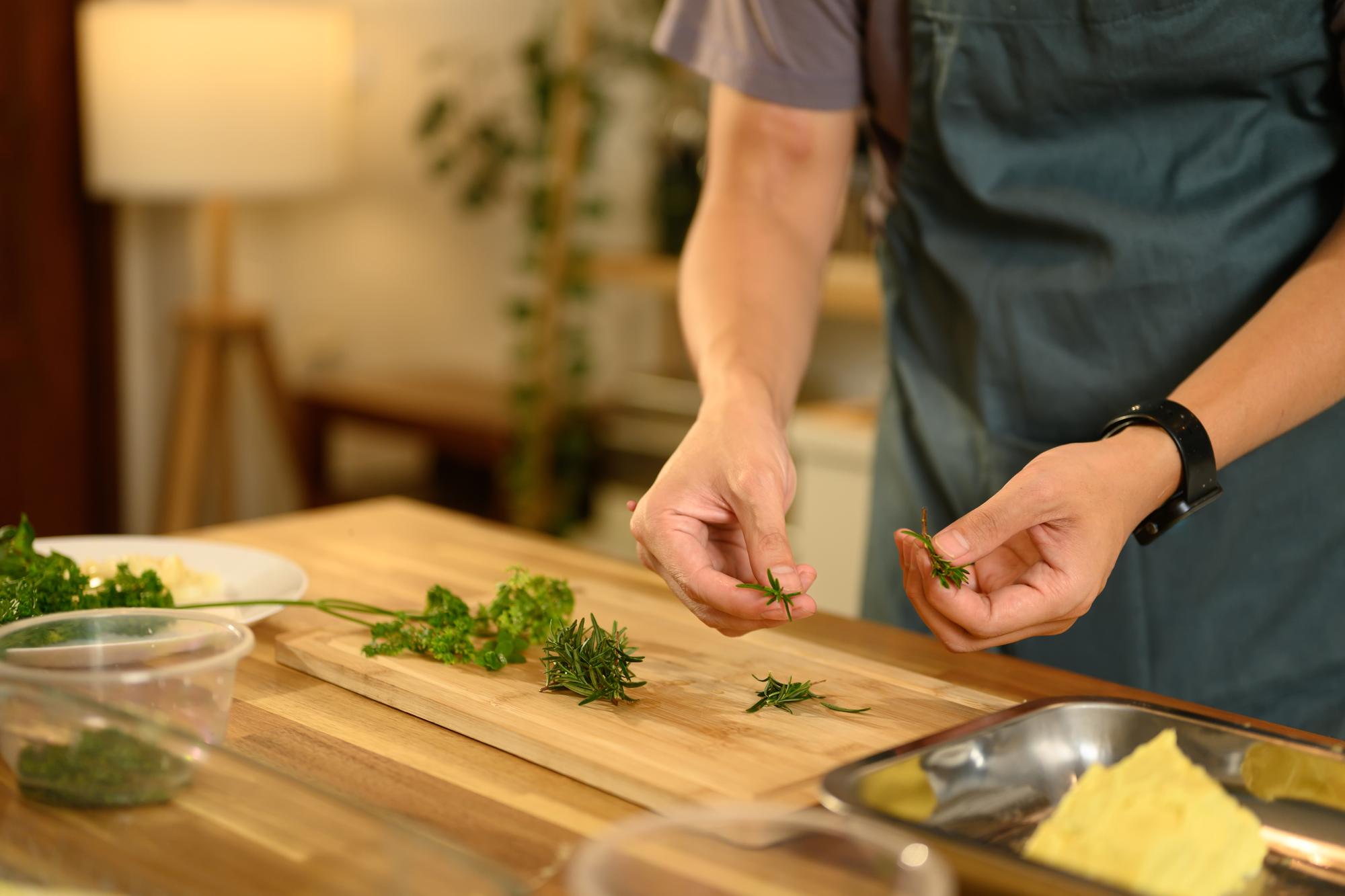 Chef arranging herbs on a wooden counter